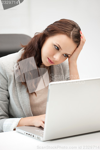 Image of pensive woman with laptop computer