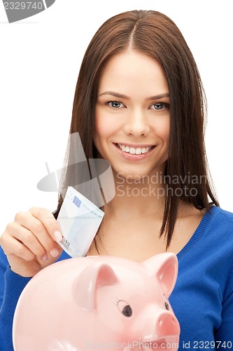 Image of lovely woman with piggy bank and money