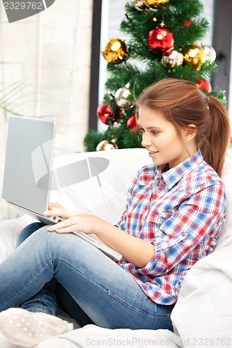 Image of woman with laptop computer and christmas tree