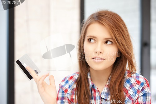 Image of pensive woman with credit card