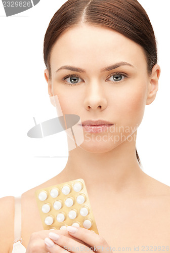 Image of young beautiful woman with pills