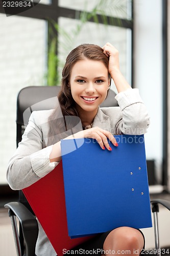 Image of young businesswoman with folders sitting in chair