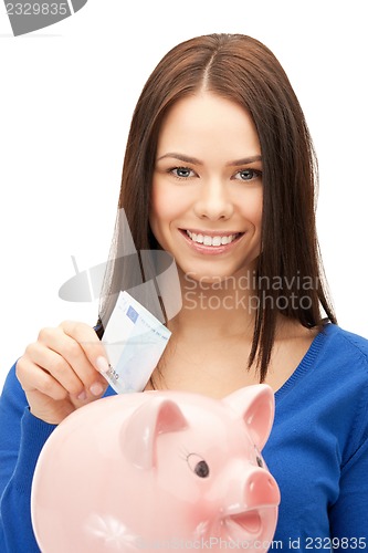 Image of lovely woman with piggy bank and money