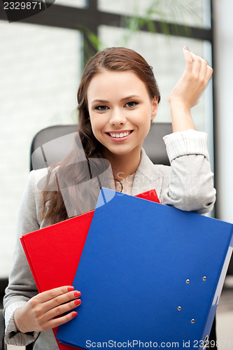 Image of young businesswoman with folders sitting in chair