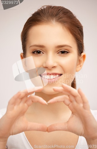 Image of happy woman making heart gesture