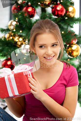 Image of happy woman with gift box and christmas tree