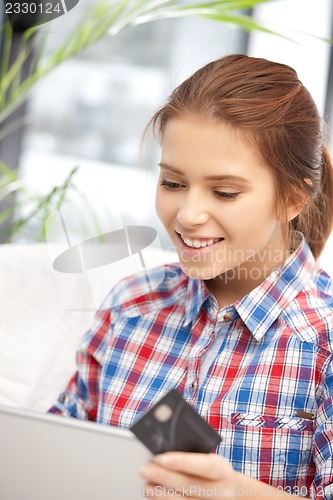 Image of happy woman with laptop computer and credit card