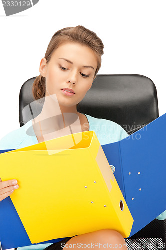 Image of young businesswoman with folders sitting in chair