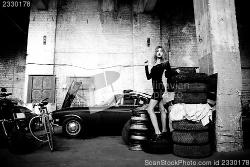 Image of fashionable woman in retro garage