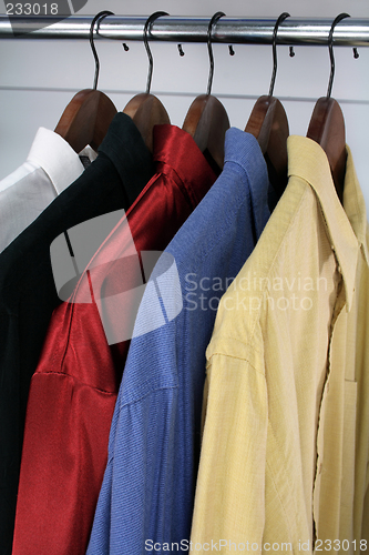 Image of Colorful shirts on wooden hangers