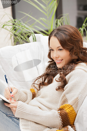 Image of happy woman with small notepad