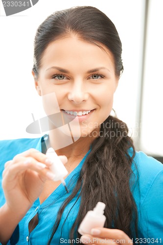 Image of beautiful woman polishing her nails