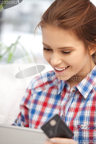 Image of happy woman with laptop computer and credit card