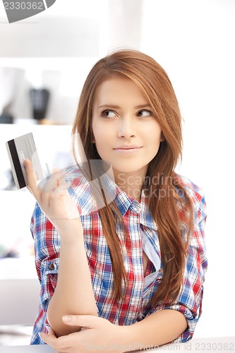 Image of pensive woman with credit card