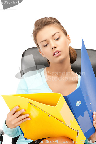 Image of young businesswoman with folders sitting in chair