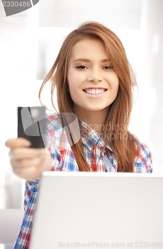 Image of happy woman with laptop computer and credit card