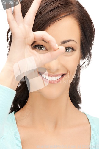 Image of lovely woman looking through hole from fingers