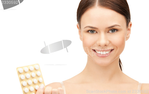 Image of young beautiful woman with pills