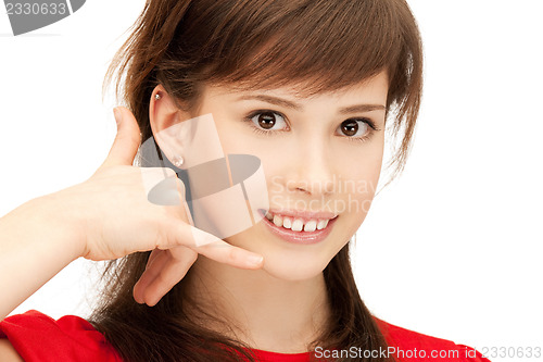 Image of teenage girl making a call me gesture