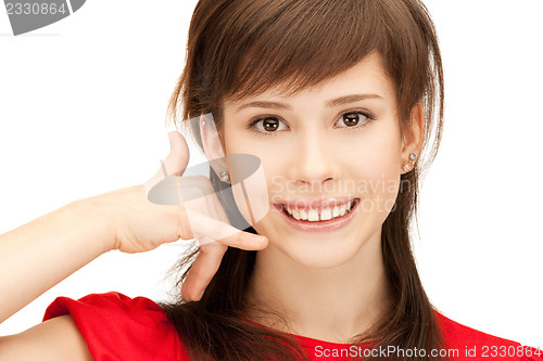 Image of teenage girl making a call me gesture
