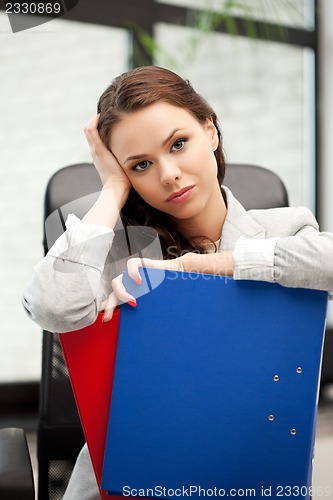 Image of young businesswoman with folders sitting in chair