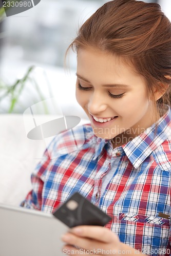 Image of happy woman with laptop computer and credit card