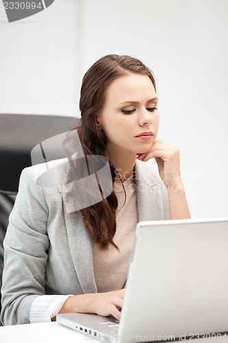 Image of pensive woman with laptop computer