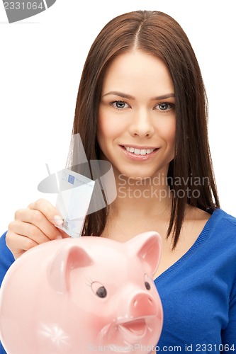 Image of lovely woman with piggy bank and money