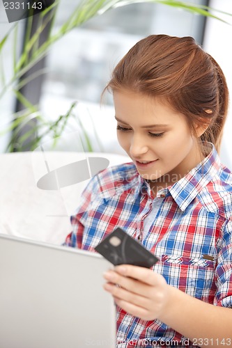 Image of happy woman with laptop computer and credit card