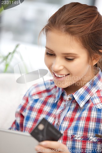 Image of happy woman with laptop computer and credit card