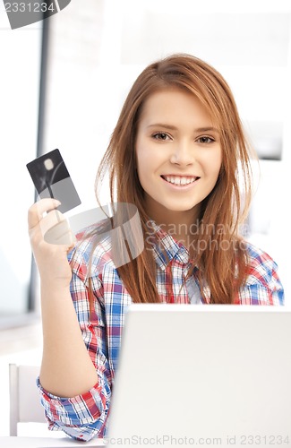 Image of happy woman with laptop computer and credit card