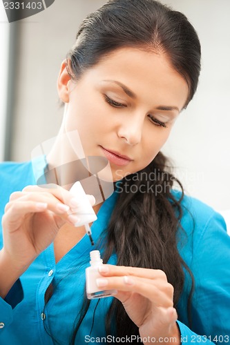 Image of beautiful woman polishing her nails