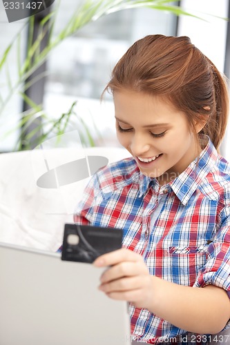 Image of happy woman with laptop computer and credit card