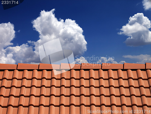 Image of Roof tiles against blue sky with clouds