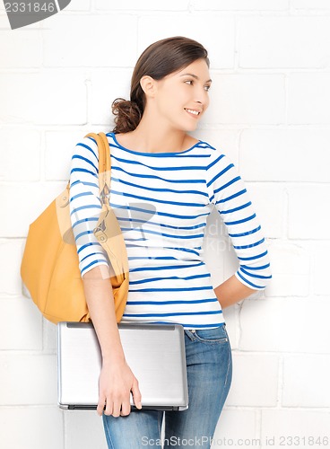 Image of happy and smiling teenage girl with laptop