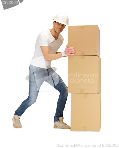 Image of handsome builder moving big boxes