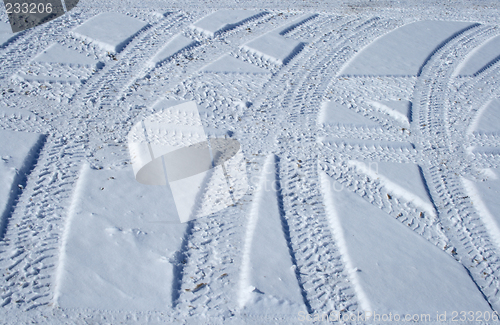 Image of Tire tracks crossing the snowy terrain