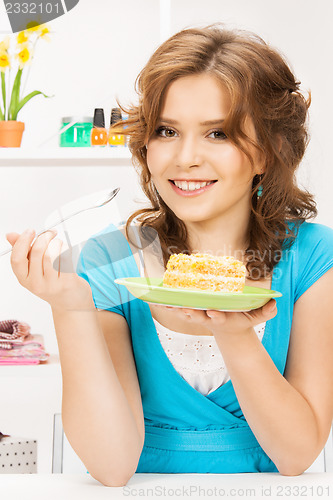 Image of lovely housewife at the kitchen with sweets