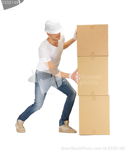 Image of handsome builder moving big boxes