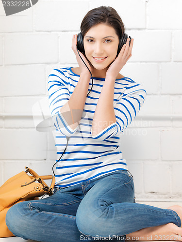 Image of happy teenage girl in big headphones