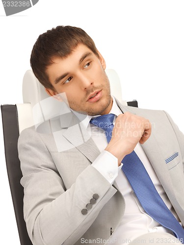 Image of young businessman sitting in chair