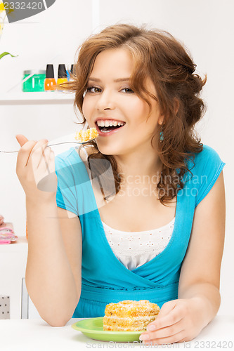 Image of lovely housewife at the kitchen with sweets