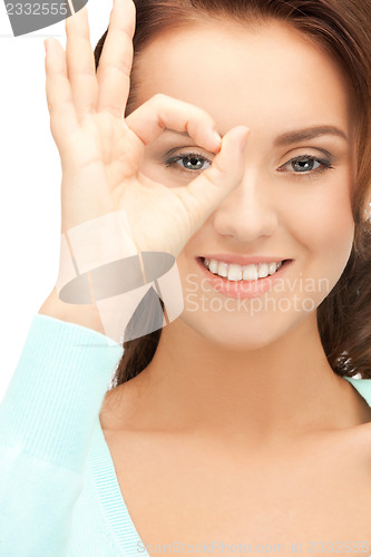 Image of lovely woman looking through hole from fingers