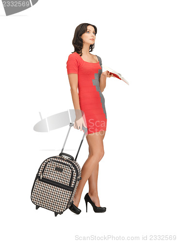 Image of pensive woman with suitcase and book