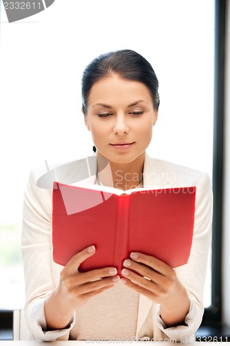 Image of calm and serious woman with book