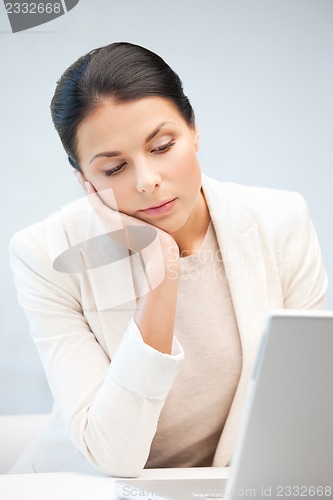 Image of pensive woman with laptop computer