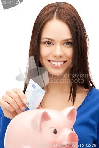 Image of lovely woman with piggy bank and money