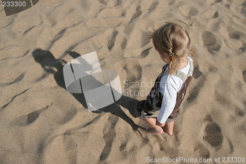Image of child and shadow in sand