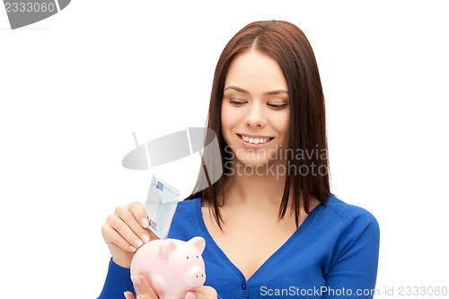 Image of lovely woman with piggy bank and money