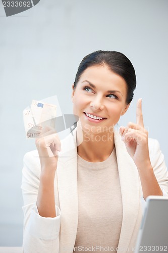 Image of happy woman with laptop computer and money